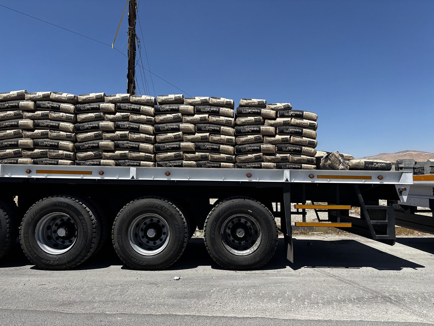 Flatbed lorry loaded with wrapped cement bags ready for delivery